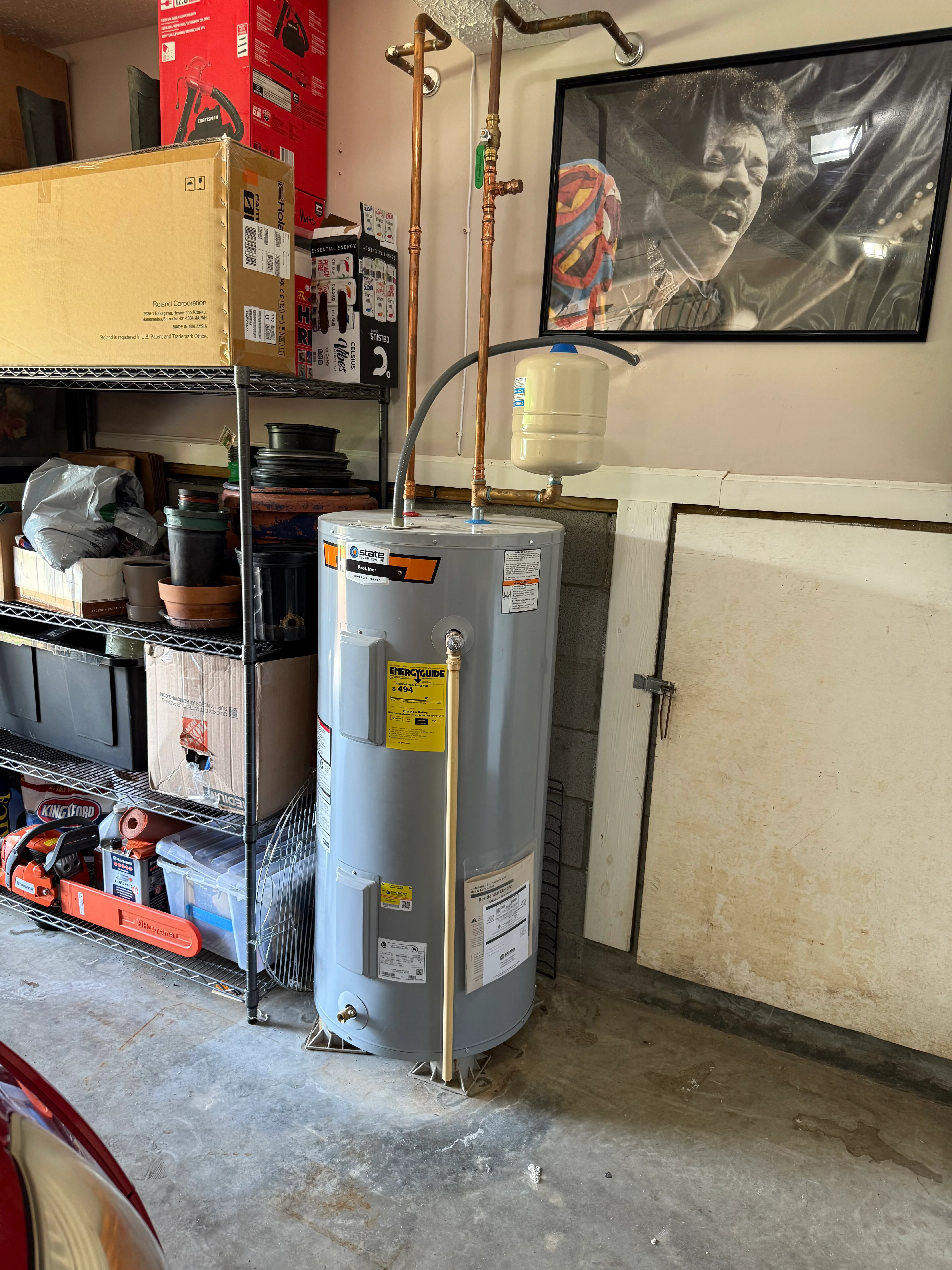 State water heater with copper piping, expansion tank, and shutoff valves installed in utility space